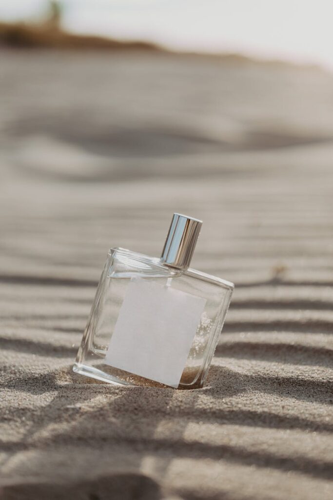glass perfume bottle on sand