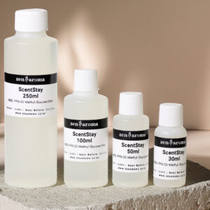 Image showing four bottles of various sizes, all labeled "ScentStay" by zenAroma. The bottles, ranging from 30ml to 250ml, stand on a textured slab against a neutral background. Rose petals are scattered to the side, adding a touch of color to the minimalist setting, emphasizing ScentStay's role as a fragrance fixative.
